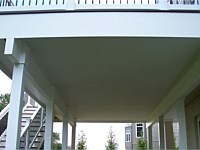 <b>Create Usable Living Space Below Your Deck with Dek Drain. The unique Dek Drain under-deck drainage system keeps rain, spills and snow melt from dripping through the decking boards above, creating a dry useable room below. Also shown here are post wraps, support beam wraps, and fascia deck wrap in low maintenance composite and vinyl materials.</b>